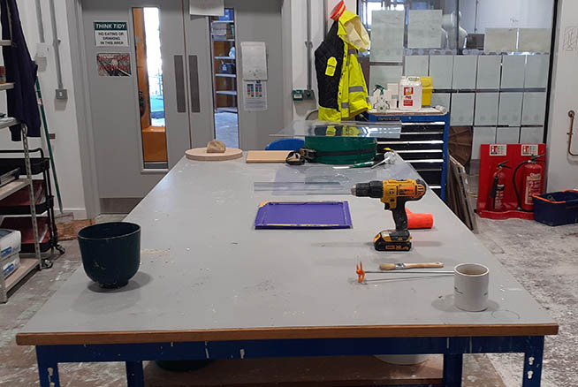 A desk with various sculpting tools and materials on it