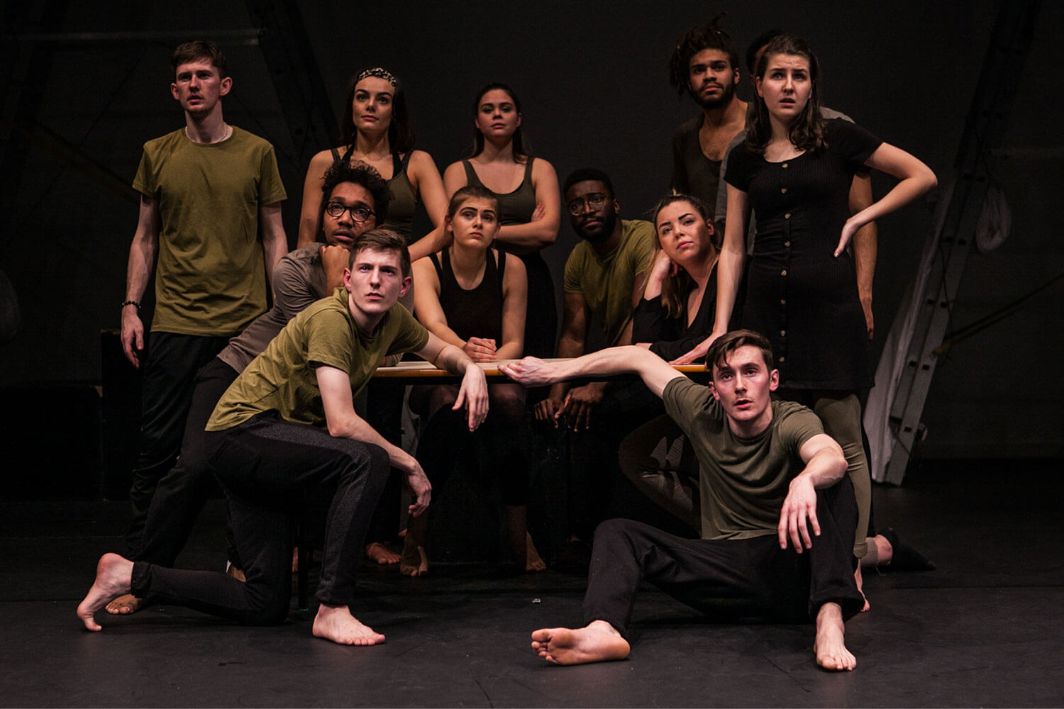 Acting students gathered on stage, staring intently towards the audience