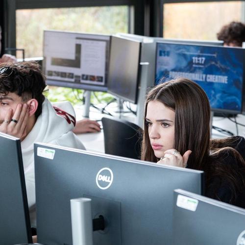 Two students looking at screens in a computer lab