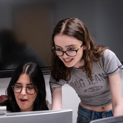 Two female students looking at a screen in a computer lab