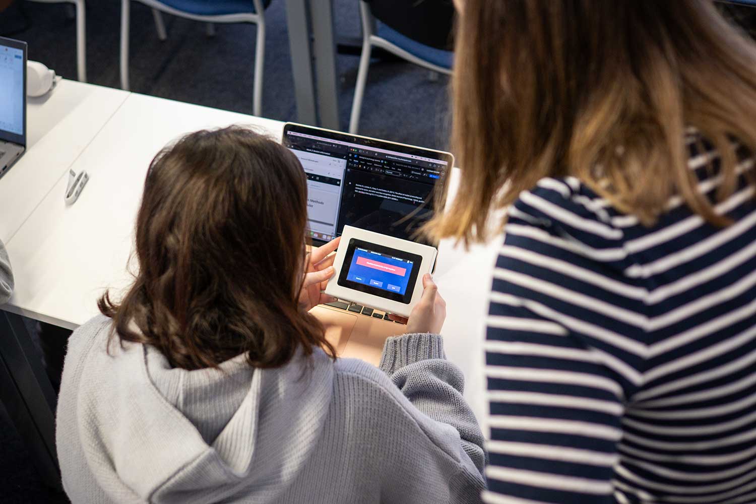 A lecturer helps a student to use digital devices