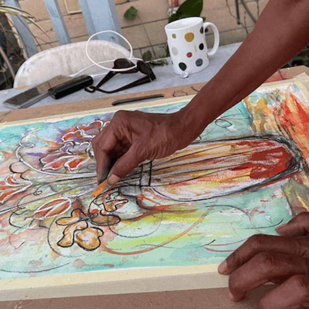 A person using pastels to draw a vase of flowers