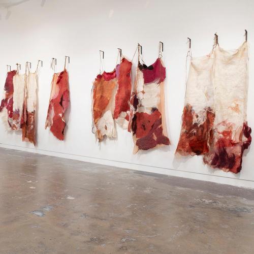 Art pieces made of wool hanging in a gallery