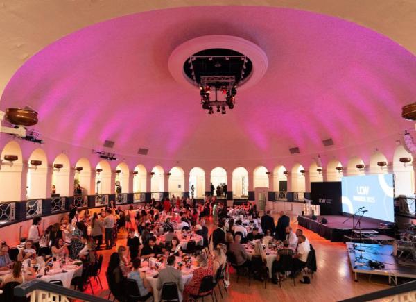 A group of people sitting under a domed roof at an awards show