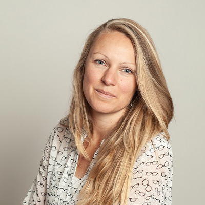 Person with long blonde hair in light coloured top