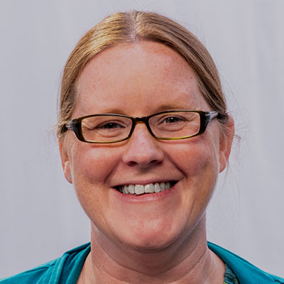 Smiling woman wearing glasses and a blue shirt