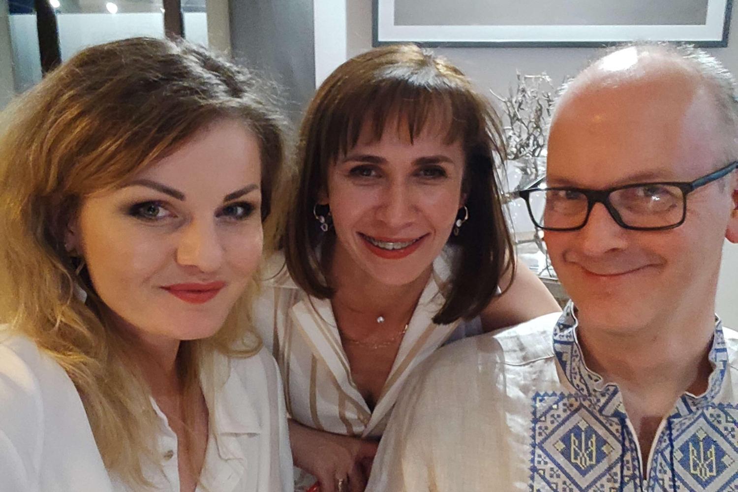 Three people smile at the camera for a selfie