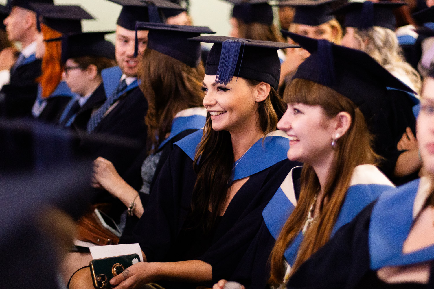 A row of students seated at Graduation wearing hats and gowns