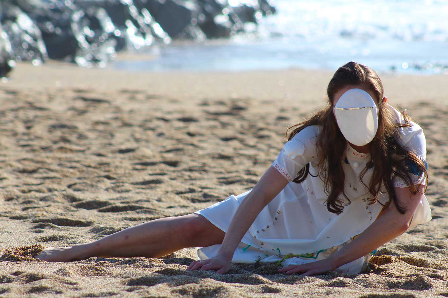 A dance lunges low to the ground on the sand